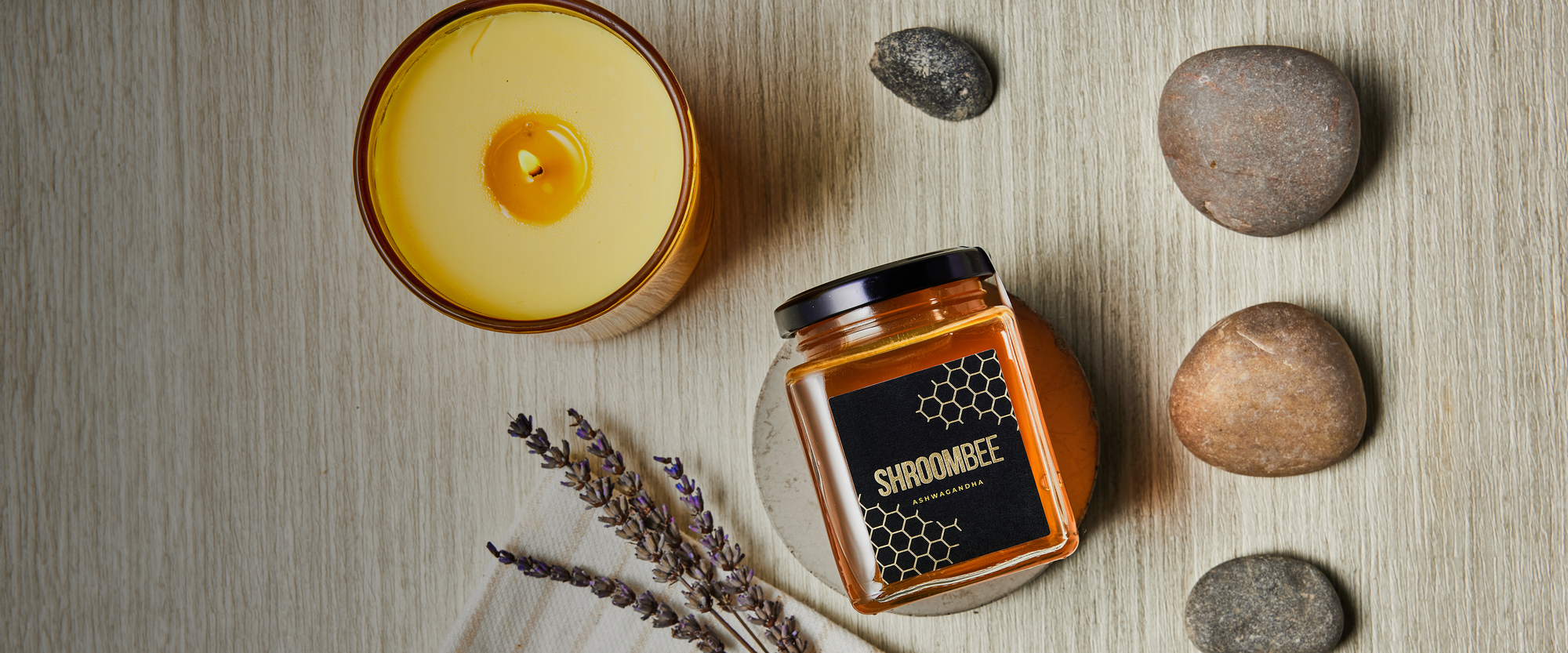 Honey, candle, and stones on a wooden surface