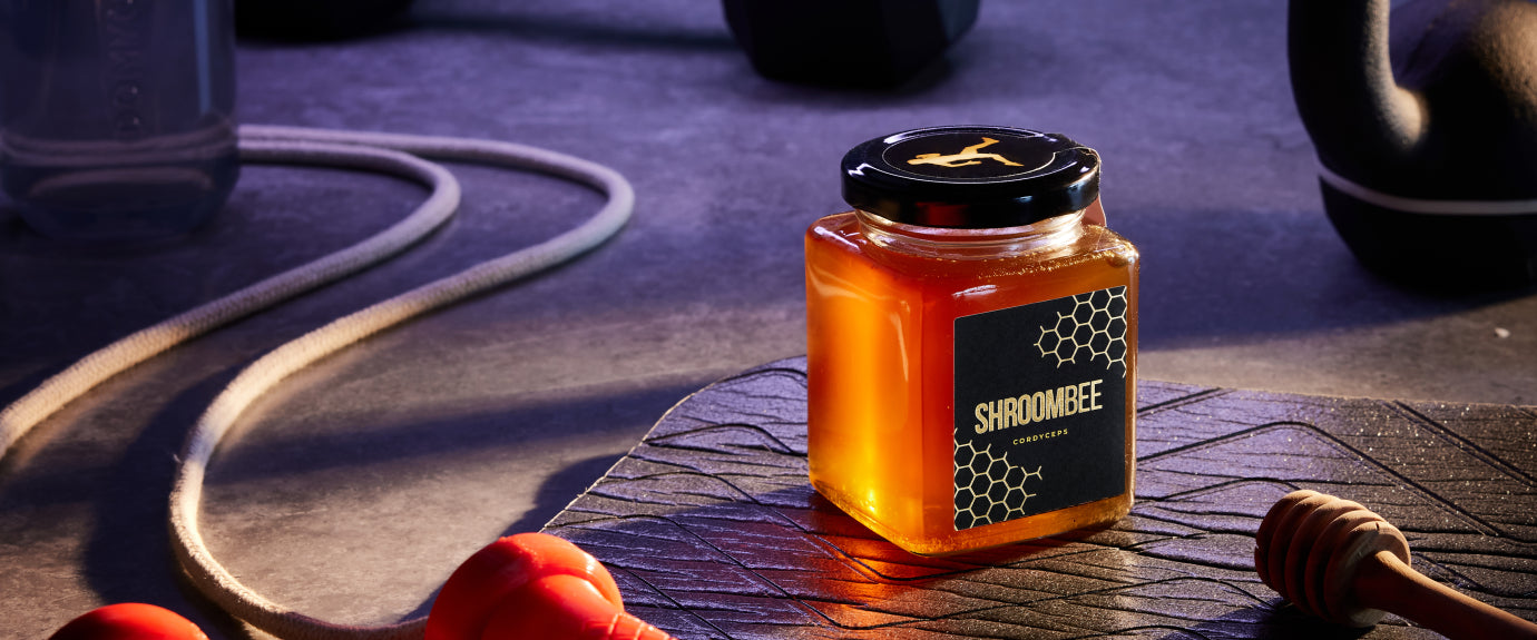 Jar of Shroomee honey on a textured surface with a blurred background